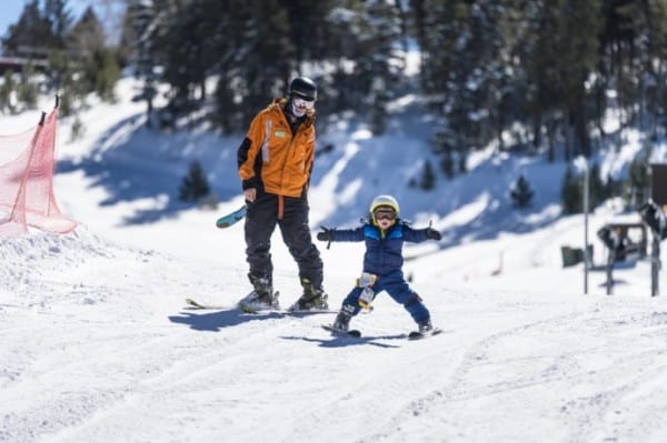 a father teaching his son how to ski